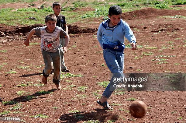 Syrian kids play footballl in Atma Refugee Camp in Atma village of Idlib, Syria on April 30, 2015. Syrians children, fled with their families from...