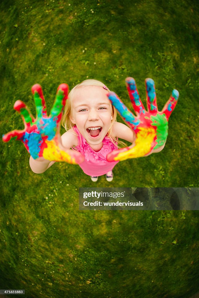 Cheerful finger painting girl in fisheye perspective