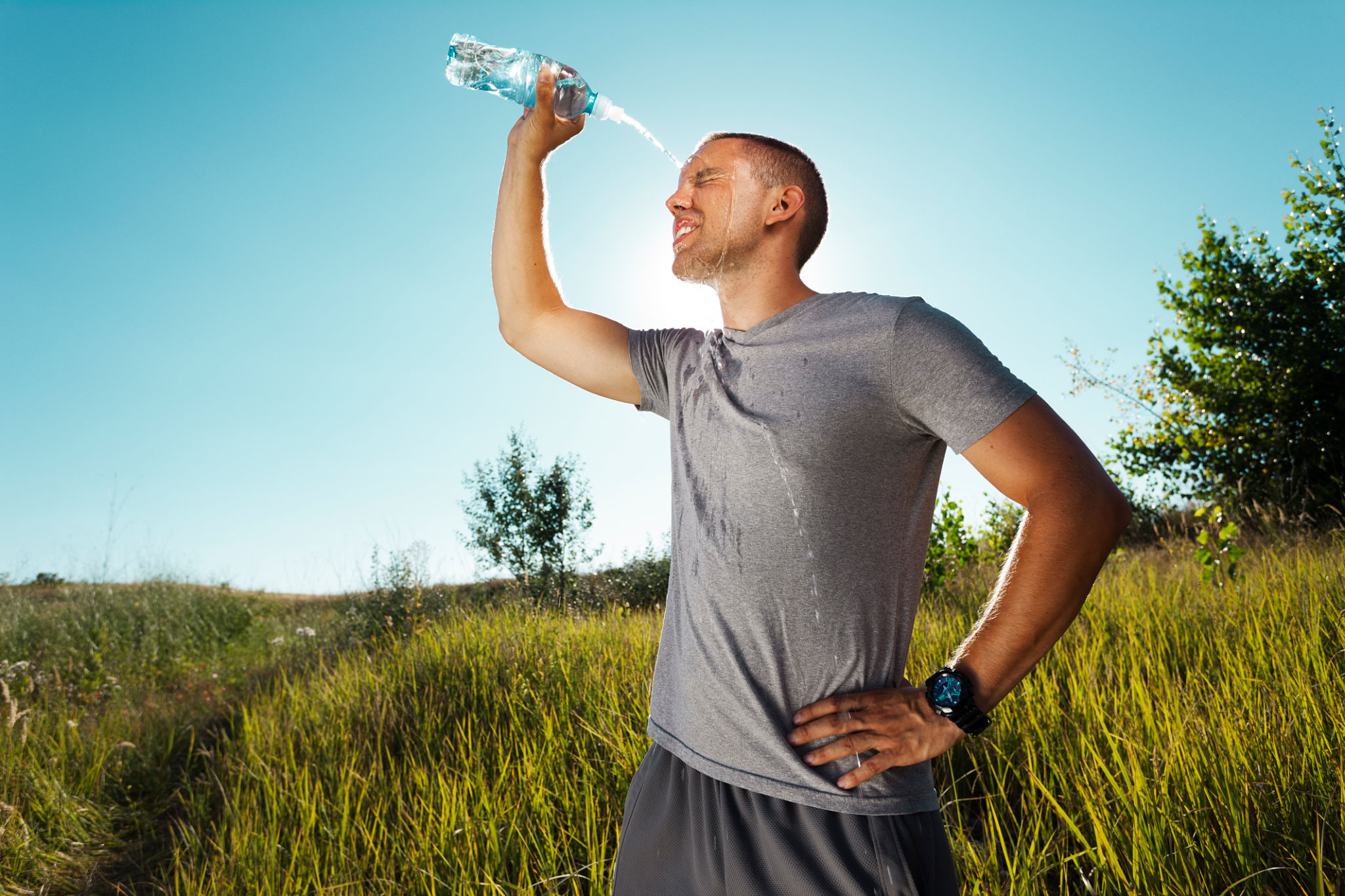 Young man refreshing himself with water Young man refreshing himself with water