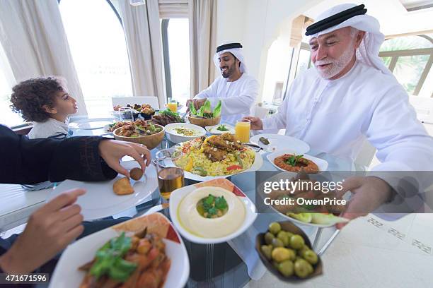 three genration arabic family enjoying lunch - traditional clothing stock pictures, royalty-free photos & images