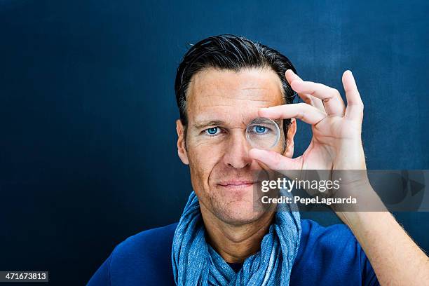 vision: man looking through lens - guy with face in hands stockfoto's en -beelden