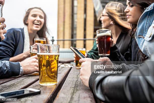 hanging out with a fresh beer in a london pub - busy pub stock pictures, royalty-free photos & images