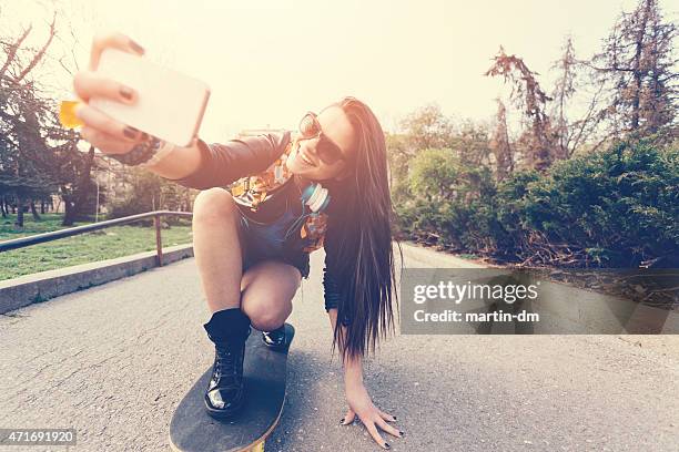 teenager-mädchen, die ein selfie auf einem skateboard - longboard surfen stock-fotos und bilder