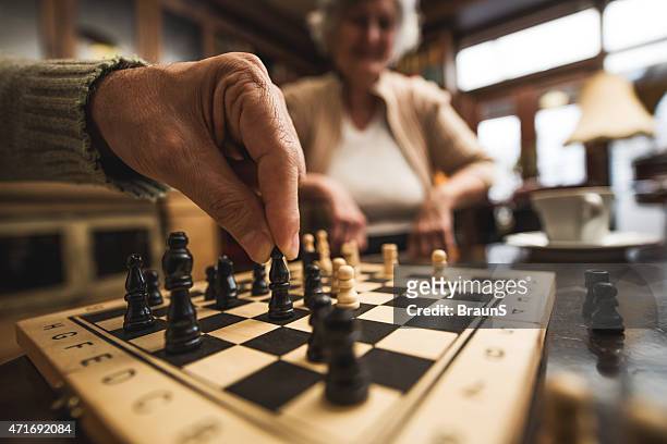 close up of senior playing chess. - senior playing chess stock pictures, royalty-free photos & images