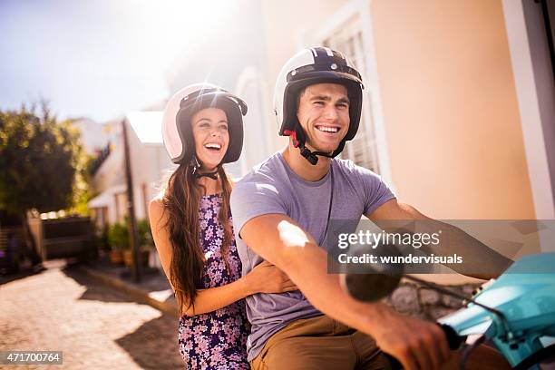 smiling couple leaving on a road trip on their scooter - girl riding scooter stockfoto's en -beelden