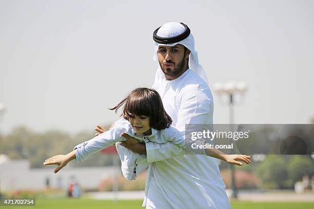 arab family enjoying their leisure time in park - dubai park stock pictures, royalty-free photos & images