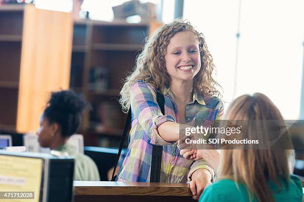 hübsche europäischer abstammung teenager mädchen schütteln hände mit college-bibliothekar - students shaking hands stock-fotos und bilder