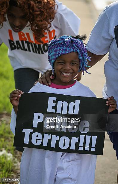 Boy holds a placard as he marches to the city hall, which is being protected by soldiers from the US Army National Guard in Baltimore, Maryland on...