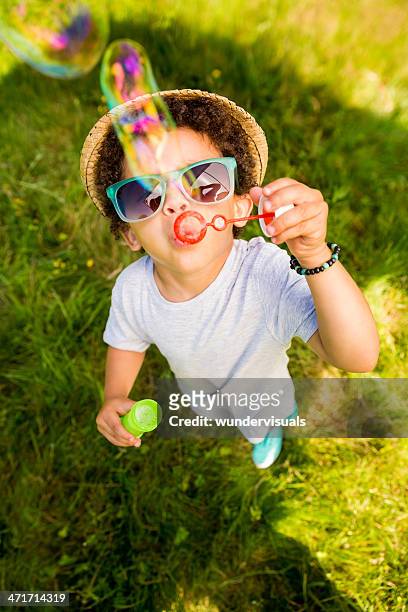 small boy having fun blowing bubbles - summer fun stockfoto's en -beelden