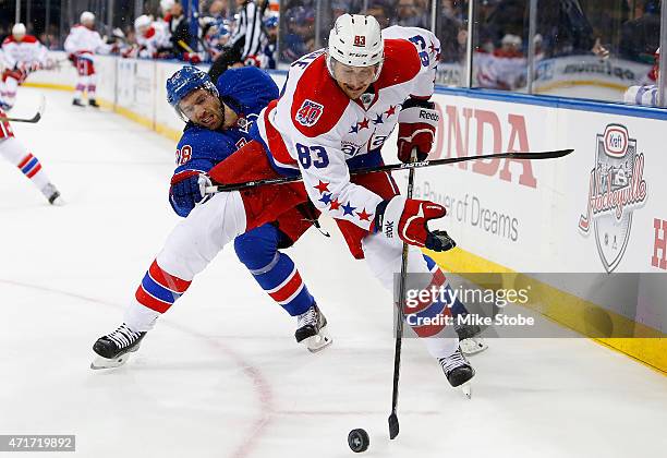 Jay Beagle of the Washington Capitals battles for the puck against Dominic Moore of the New York Rangers in Game One of the Eastern Conference...