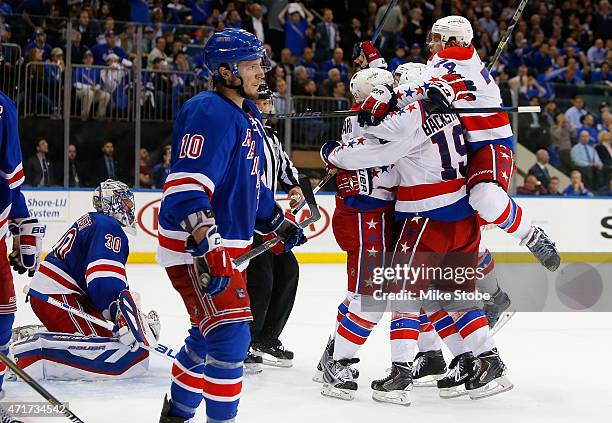 Joel Ward of the Washington Capitals is mobbed by his teamates after scoring the game winning goal at 19:58 as Henrik Lundqvist and J.T. Miller of...