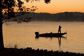 Bass Fisherman on Lake at Dawn