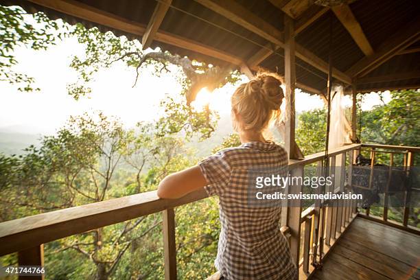 woman on tree house looking at sunset - tree house stock pictures, royalty-free photos & images