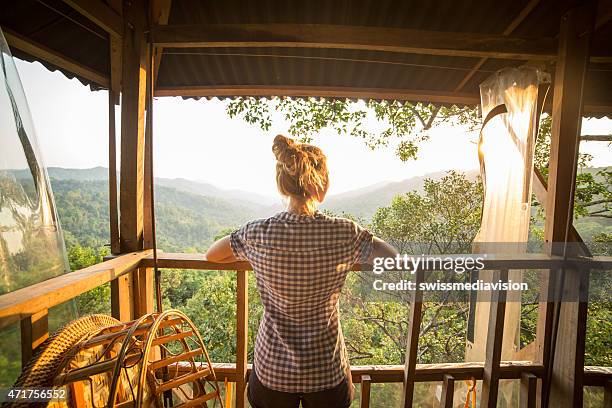 woman on tree house watching sunset - tree house stock pictures, royalty-free photos & images