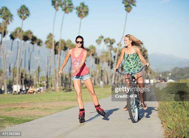 women with skates and bicycle beach cruiser in santa barbara - santa barbara california stock pictures, royalty-free photos & images