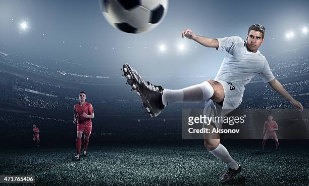 low angle action shot of a kicked soccer ball and players - shooting at goal stock pictures, royalty-free photos & images
