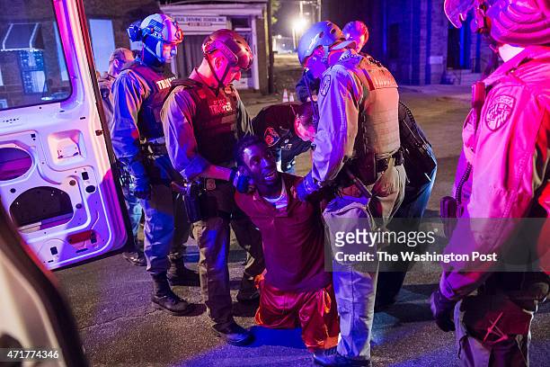 Officers arrest a man after the 10 p.m. Curfew on West North Avenue as protestors walk for Freddie Gray around the city in Baltimore, MD on Wednesday...