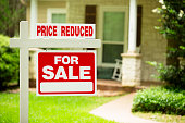 House for sale, price reduced. Real estate sign. Front yard.