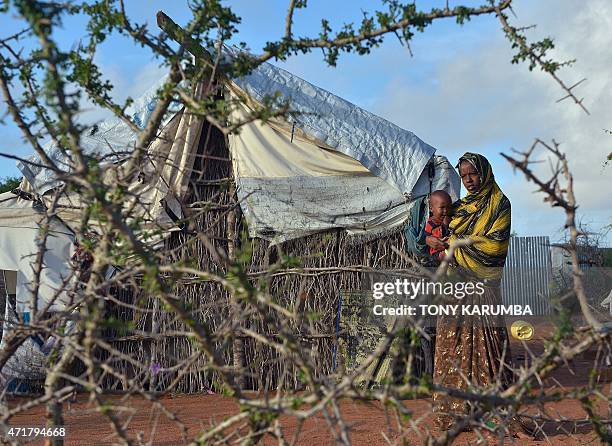 Somali refugee woman with her child stand in their compound at Hagadera sector of the Dadaab refugee camp, north of the Kenyan capital Nairobi, on...