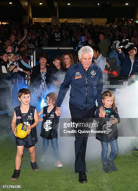 Michael Malthouse the coach of the Blues walks out onto the field with his grandchildren during the round five AFL match between the Carlton Blues...