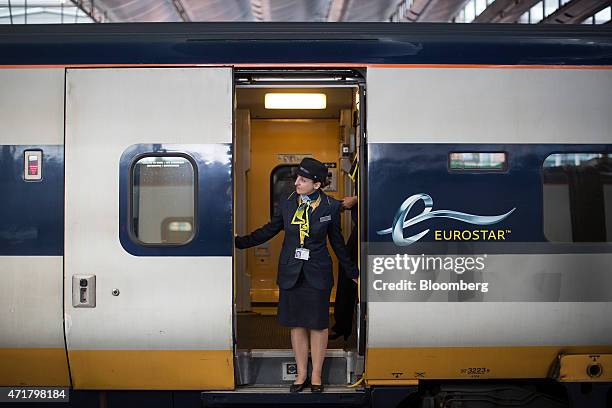 Eurostar employee stands in the doorway of passenger train operated by Eurostar International Ltd. At St Pancras International railway station in...