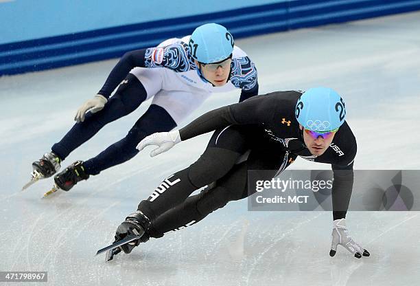 The USA's Eduardo Alvarez leads Russia's Semen Elistratov during the short track men's 5000m relay final at the Iceberg Skating Palace at the Winter...