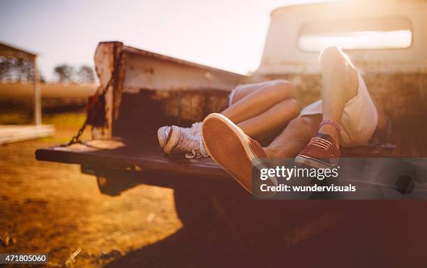 legs of teen pareja beso en la parte posterior de vintage camión - man touching womans leg fotografías e imágenes de stock