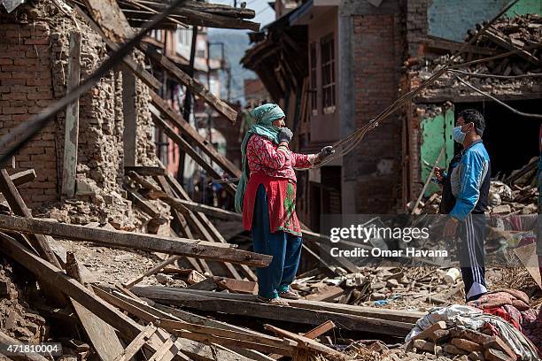 Neighbours speak in a square covered by debris from collapsed houses on May 1, 2015 in Harisiddhi, Nepal. A major 7.8 earthquake hit Kathmandu...