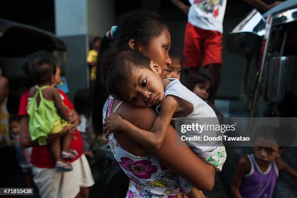 Emaciated child is held by his mother during a protest rally to commemorate international labor day on May 1, 2015 in Manila, Philippines. Thousands...