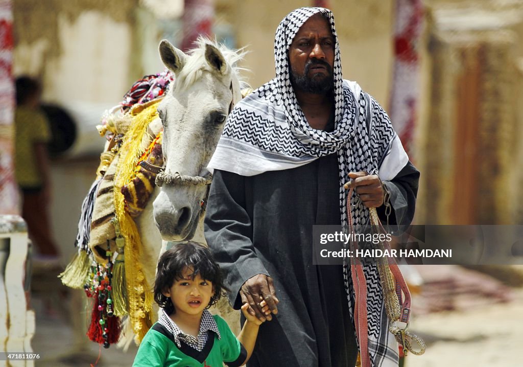 Codman Ghajar A man from the from the Ghajar community walks with a child and a ...