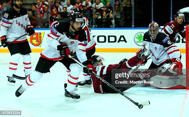 Dan Hamhuis of Canada and Janis Sprukts of Latvia battle for the puck during the IIHF World Championship group A match between Canada and Latvia at...
