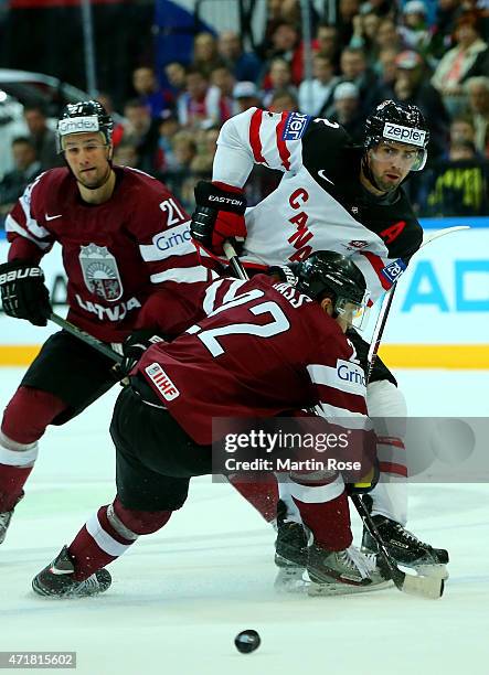 Dan Hamhuis of Canada and Maris Jass of Latvia battle for the puck during the IIHF World Championship group A match between Canada and Latvia at o2...