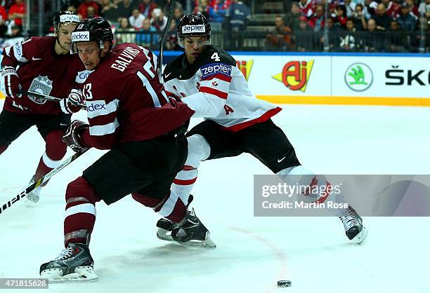 Taylor Hall of Canada and Guntis Galvins of Latvia battle for the puck during the IIHF World Championship group A match between Canada and Latvia at...