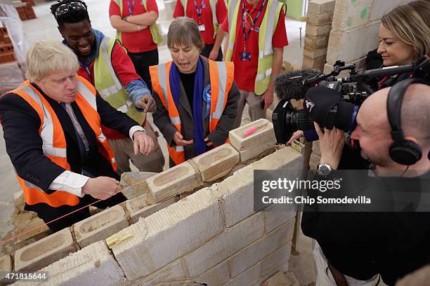 London Mayor Boris Johnson and Angie Bray , Conservative candidate for Ealing Central and Acton, get a lesson in bricklaying from Ealing, Hammersmith...