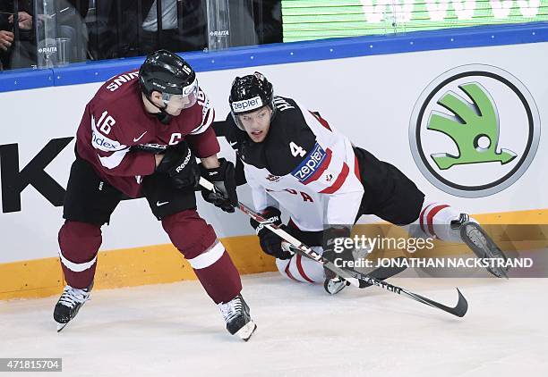 Latvia's forward Kaspars Daugavins and Canada's forward Taylor Hall vie for the puck during the group A preliminary round ice hockey match Canada vs...