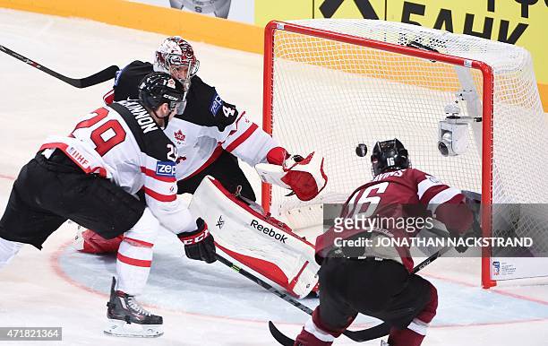 Latvia's forward Kaspars Daugavins shoots to score past Canada's goalkeeper Mike Smith during the group A preliminary round ice hockey match Canada...