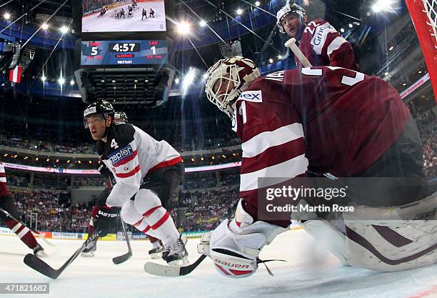 Taylor Hall of Canada fails to score over Edgars Masalskis , goaltender of Latvia battle for the puck during the IIHF World Championship group A...