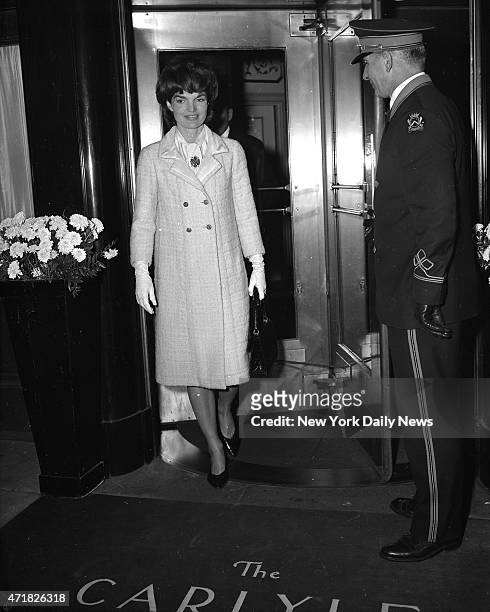 Mrs. Jacqueline Kennedy cuts a bright figure as she leaves Carlyle Hotel to do some Christmas shopping. The First Lady said she was going to buy a...