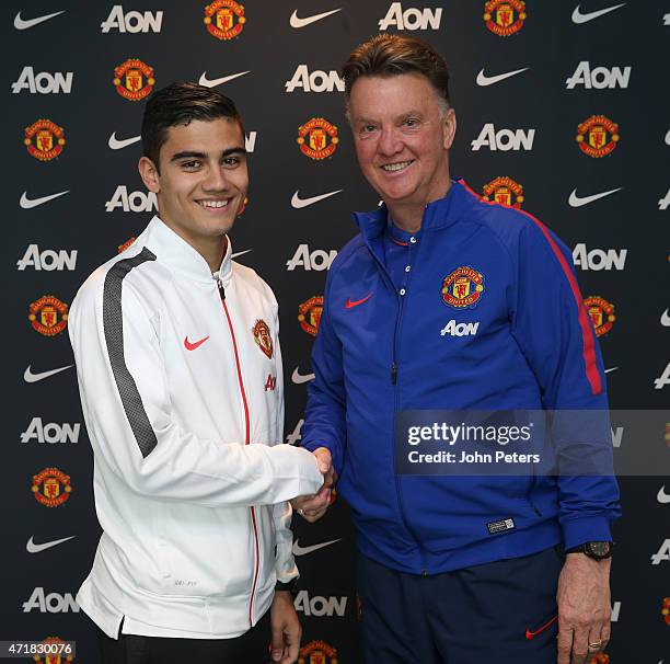 Andreas Pereira of Manchester United poses with manager Louis van Gaal after signing a contract extension at Aon Training Complex on May 1, 2015 in...