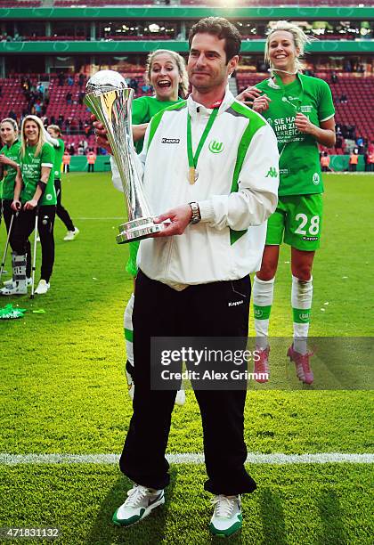 Head coach Ralf Kellermann of Wolfsburg poses with the trophy after winning the Women's DFB Cup Final between Turbine Potsdam and VfL Wolfsburg at...