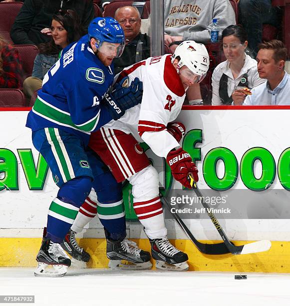 Yannick Weber of the Vancouver Canucks checks Jordan Szwarz of the Arizona Coyotes during their NHL game at Rogers Arena April 9, 2015 in Vancouver,...