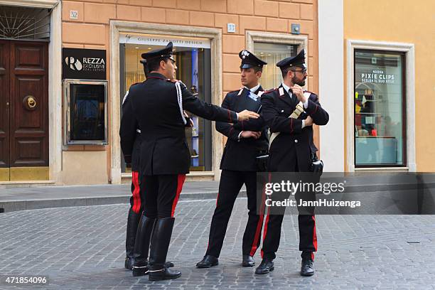 vier carabinieri offiziere plaudern auf der gepflasterten straße in rom, italien - carabinieri stock-fotos und bilder