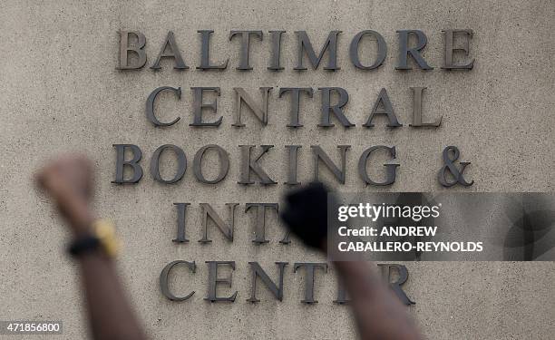 Protesters raise up their fists outside the Baltimore Police Central Booking and Intake Center for prisoners in Baltimore, Maryland on May 1, 2015....