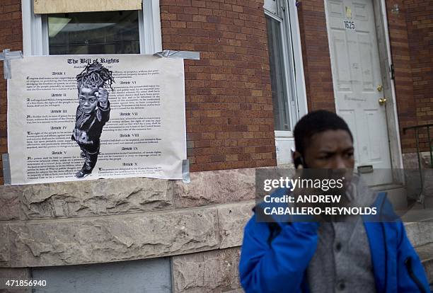 Man talks on a phone near a poster for the Bill of Rights in the Western District in Baltimore, Maryland on May 1, 2015. Six Baltimore police...