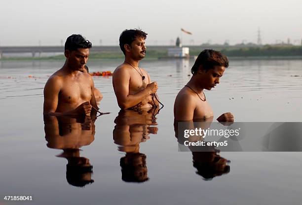 hindu men pray in the yamuna river - religious offering stock pictures, royalty-free photos & images