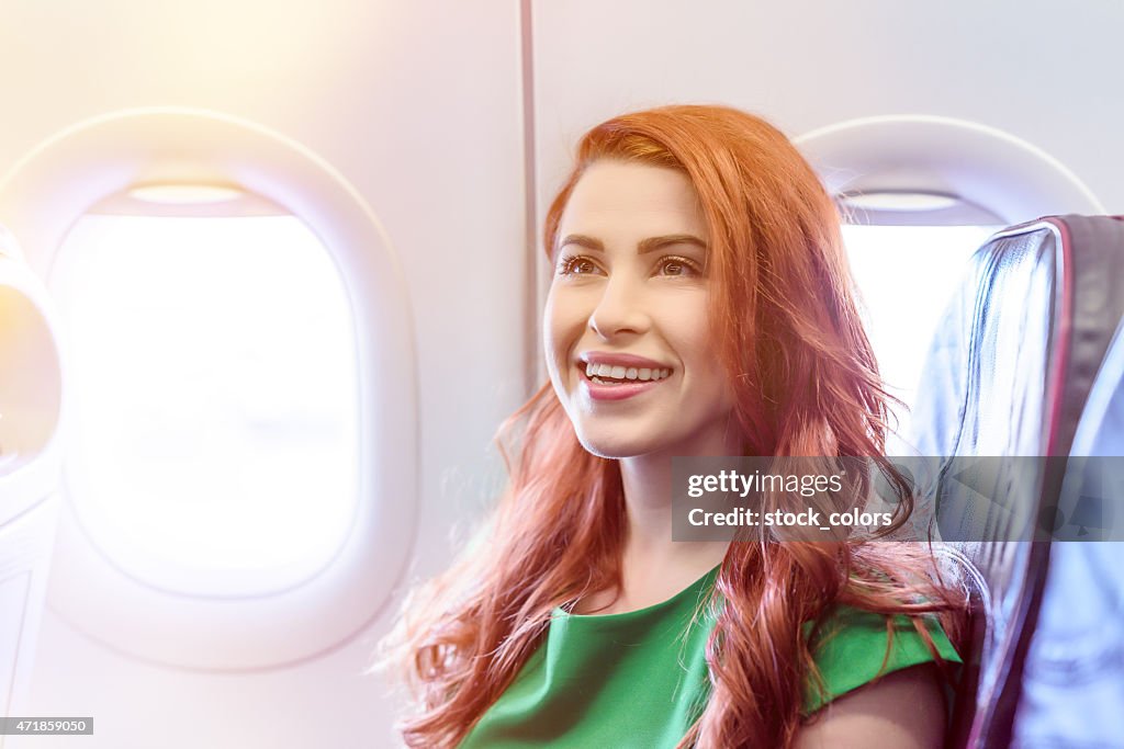 Happy woman inside airplane