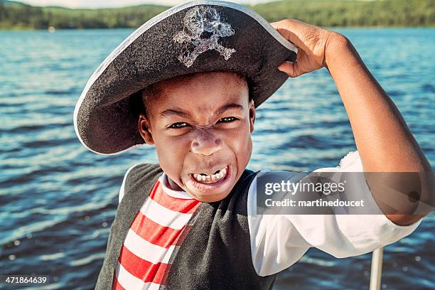 very expressive african-american child dressed as pirate on a lake. - fancy dress stockfoto's en -beelden