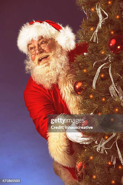 pictures of vintage real santa claus hiding behind christmas tre - old fashioned santa stock pictures, royalty-free photos & images