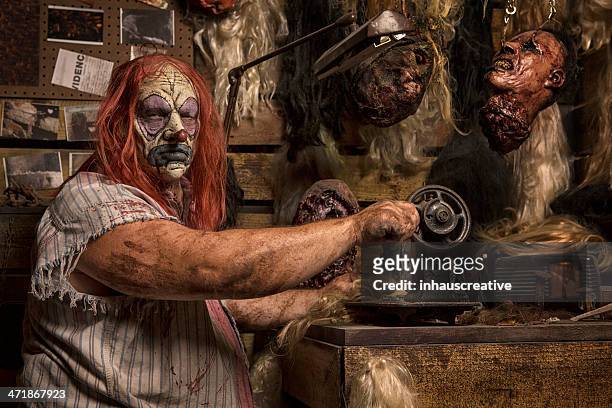 serial killer clown sewing in his cabin - serial killings stock pictures, royalty-free photos & images