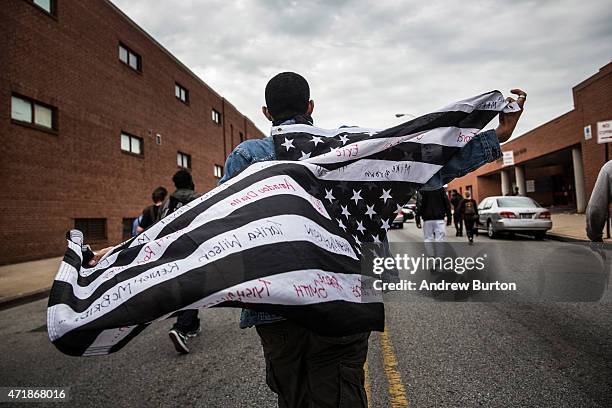 Protesters march through the streets in support of Maryland state attorney Marilyn Mosby's announcement that charges would be filed against Baltimore...